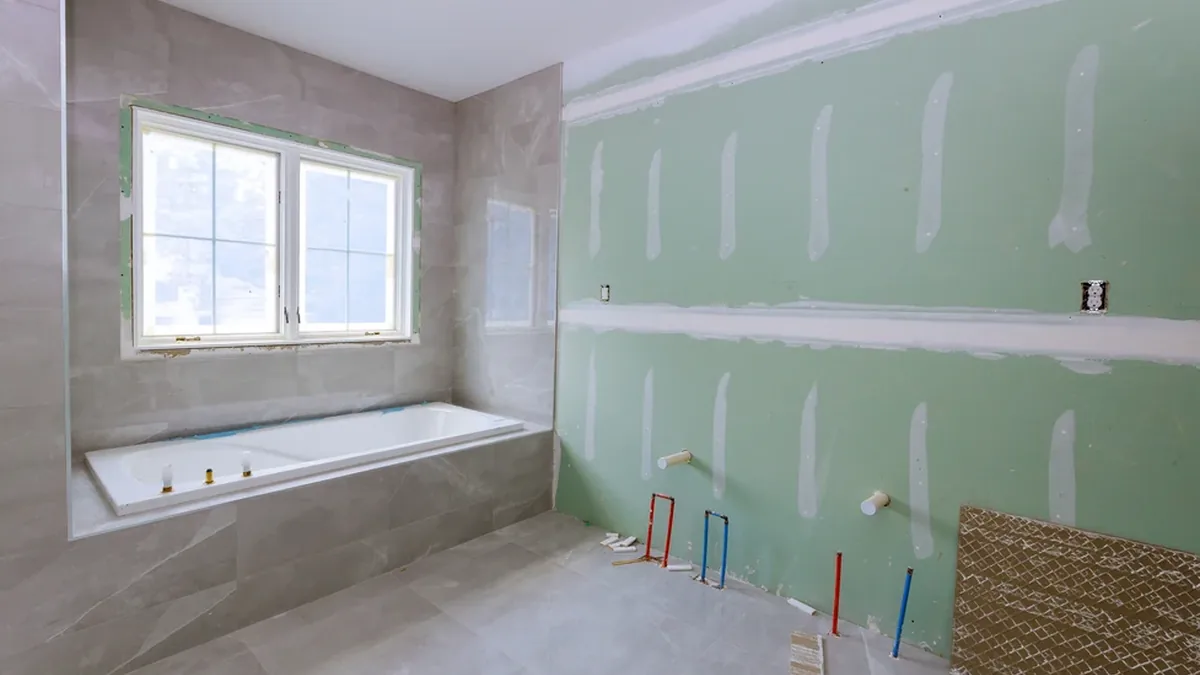 Baño en obra con paredes de placa verde antihumedad de pladur en una vivienda del Mar Menor